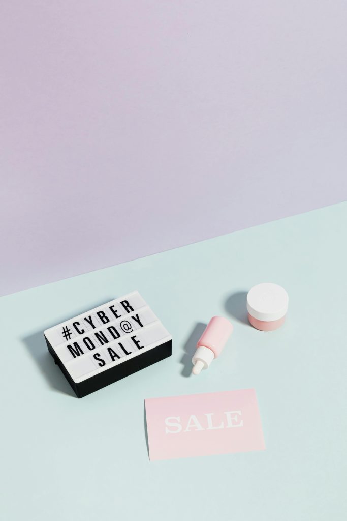 Flat lay de produits de beauté et de panneaux de soldes mettant en avant les réductions du Cyber Monday