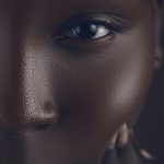 Rich et gros plan artistique détaillé d'un visage de femme africaine, montrant une peau texturée et un regard profond.