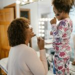 Une maman et une fille profitant ensemble d'une routine de soins ludique dans la salle de bain.