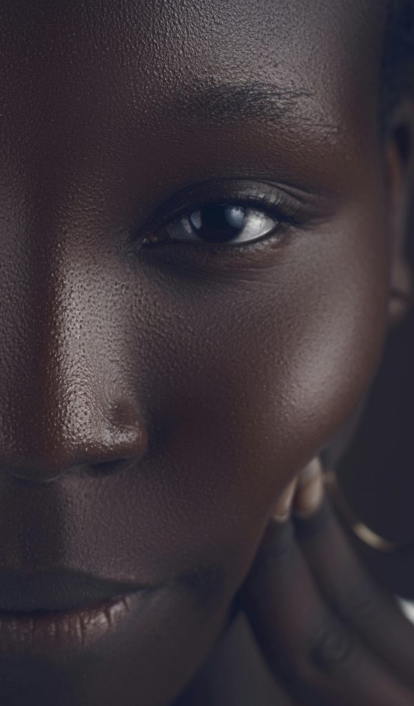 Rich et détaillé gros plan artistique du visage d'une femme africaine, montrant une peau texturée et un regard profond.