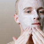 Close-up d'un homme appliquant un nettoyant pour le visage pour une routine de soins rafraîchissante, mettant l'accent sur les soins personnels et la santé.