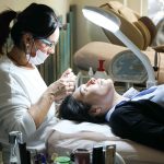 Beautician carefully performs a facial treatment on a woman in a spa setting, ensuring relaxation and care. Une esthéticienne effectue soigneusement un soin du visage sur une femme dans un cadre de spa, assurant détente et soin.