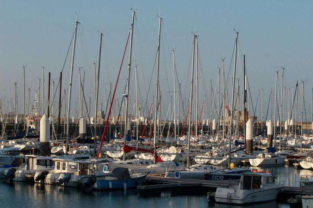 A serene view of sailboats docked at Le Havre Marina in Normandy, France. Une vue sereine de voiliers amarrés à la Marina du Havre en Normandie, France.