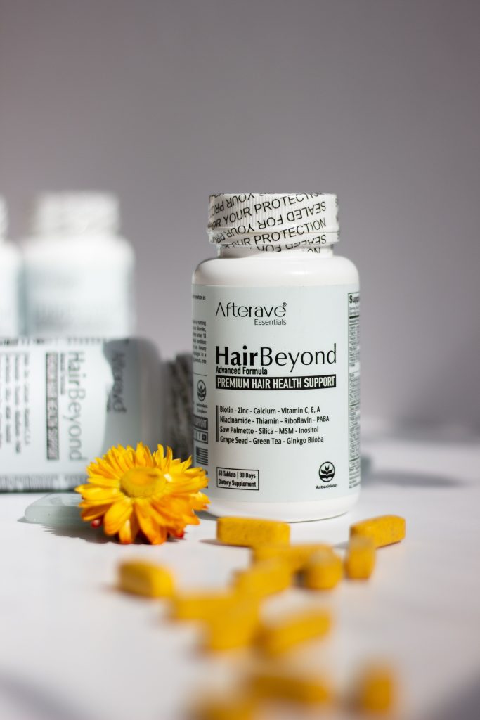 HairBeyond premium hair health supplement bottles with vitamins in focus. Flacons de supplément capillaire premium HairBeyond avec vitamines en focus.