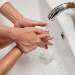 From above of crop unrecognizable mom washing hands of kid in big white washing basin Vue de dessus d'une mère méconnaissable lavant les mains d'un enfant dans un grand bassin blanc