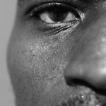 Gros plan monochrome intense du visage d'un homme avec texture détaillée et transpiration.