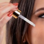 A woman applies skincare serum using a dropper for healthy skin beauty routine. Une femme applique un sérum de soin de la peau à l'aide d'un compte-gouttes pour une routine de beauté de la peau saine.