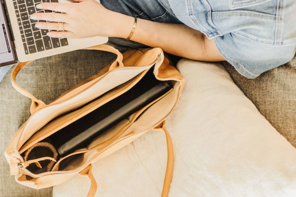Sac cabas en cuir posé sur un canapé avec un ordinateur portable