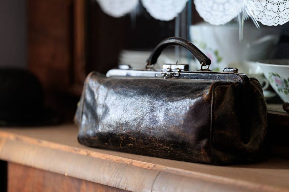 Sac en cuir patiné posé sur une étagère en bois