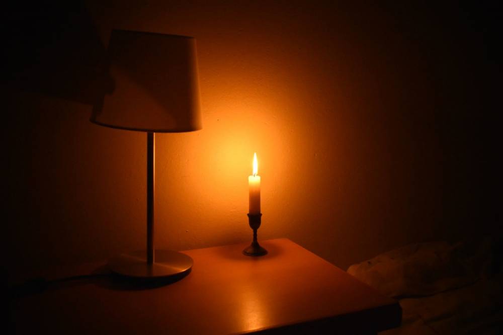 Bougie allumée créant une ambiance douce dans une chambre
