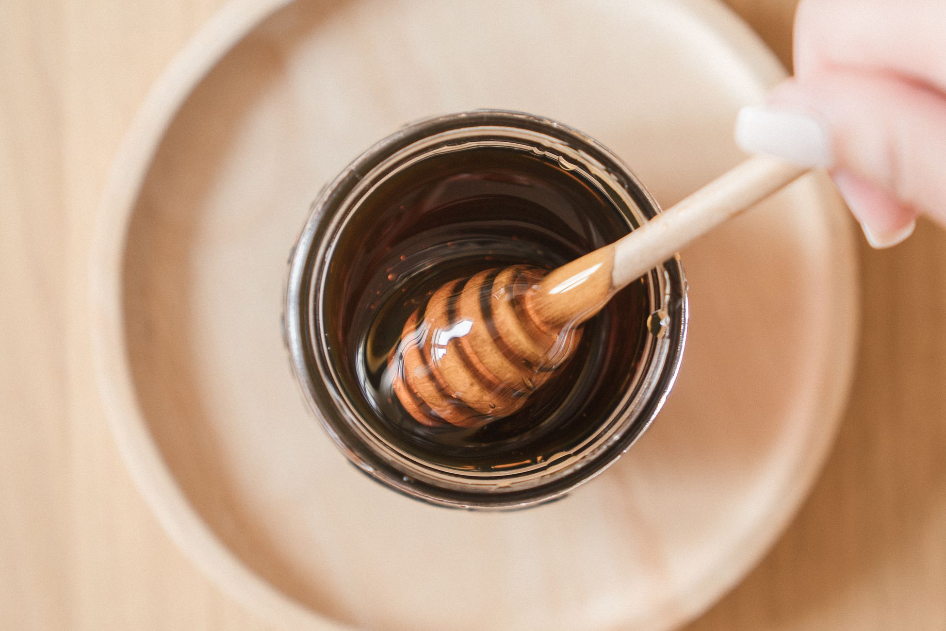 Jar de miel et cuillère en bois sur plateau en bois