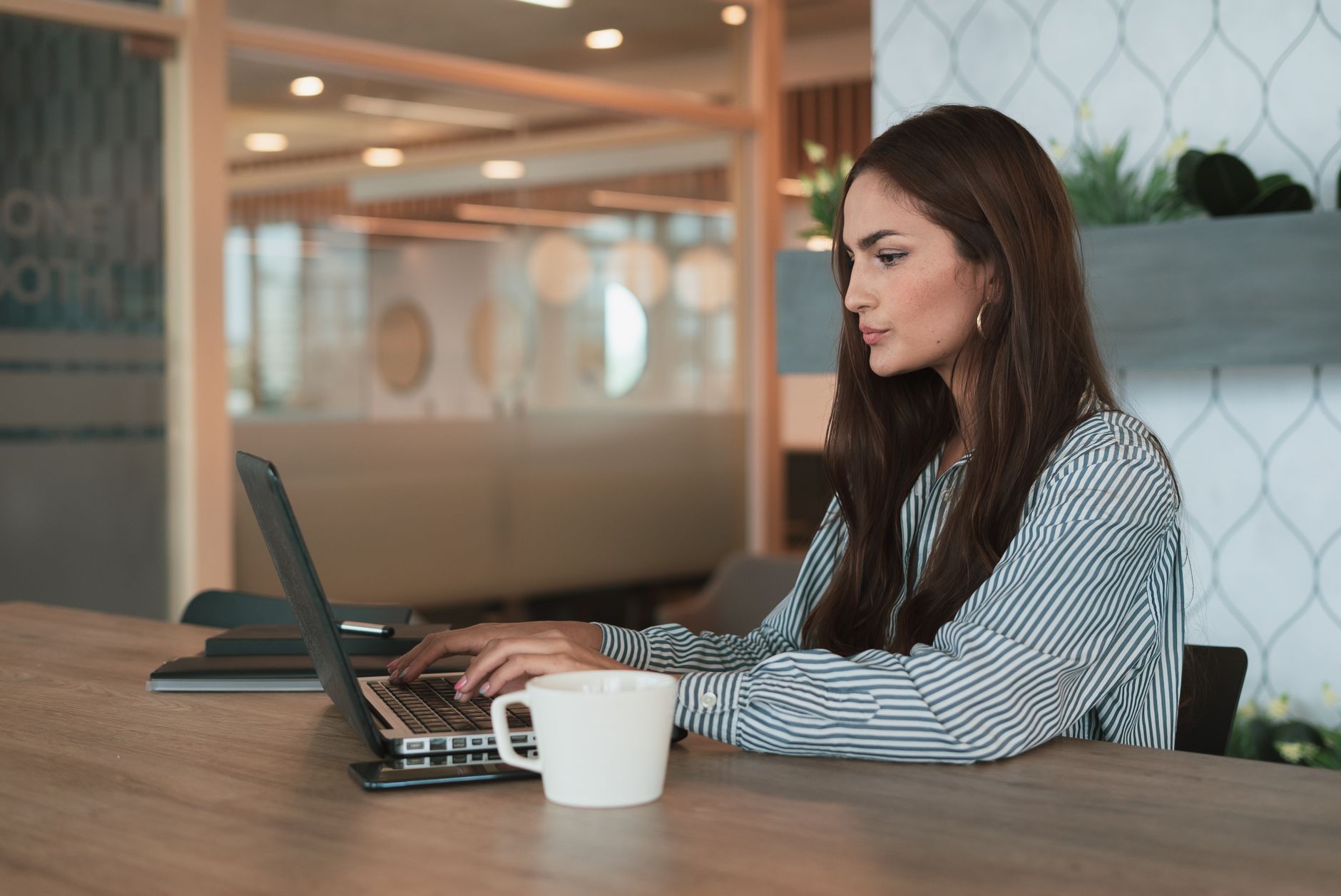 Femme au travail avec une tasse de café