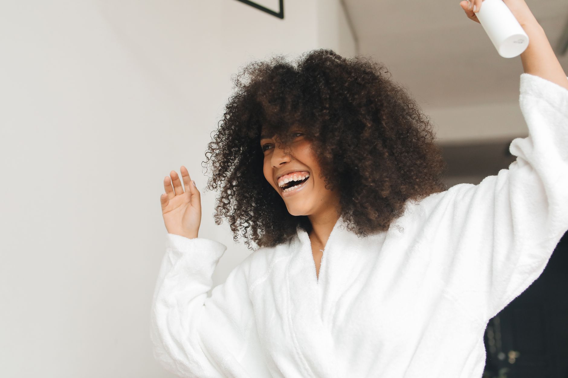 Jeune femme aux cheveux bouclés détendue en peignoir