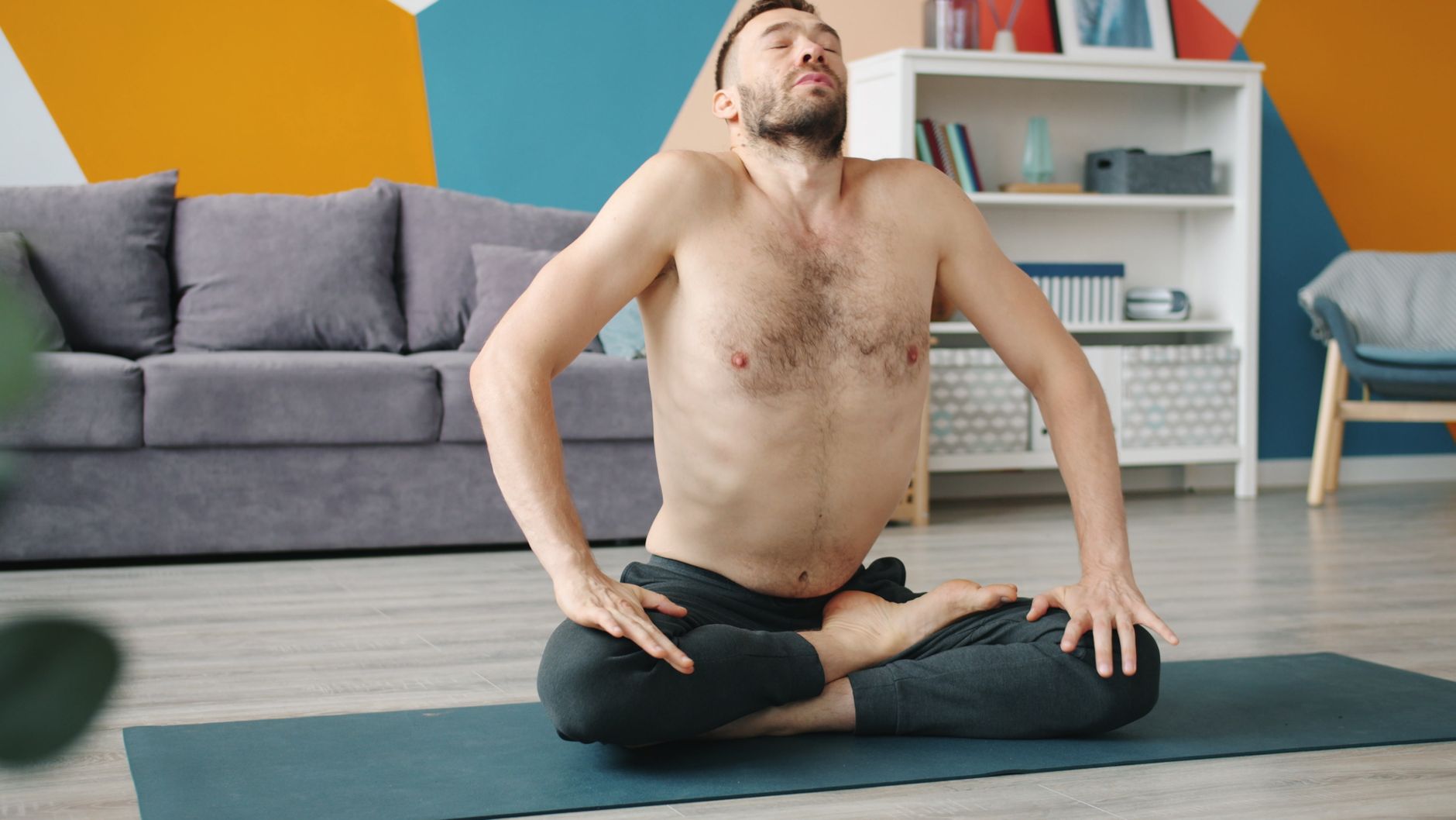 Homme en posture de respiration consciente au salon